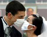 A newly-wed couple kisses through their face masks at the Tiananmen Square in Beijing
