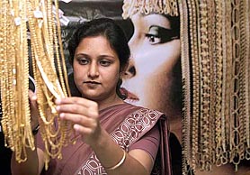 An employee of a jewellery shop displays gold chains