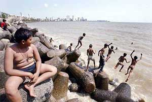 Young street urchins jump into the Arabian Sea