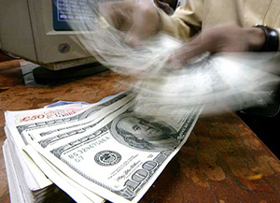 A money changer counts US dollars in Mumbai