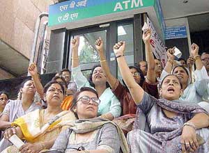 Bank workers chant slogans in front of a bank