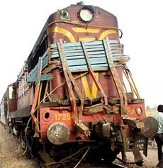 The wreckage of a truck is pressed against the engine of a passenger train after a collision near Ramnathpur railway station in Uttar Pradesh on Tuesday.