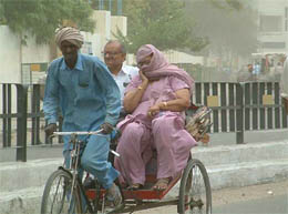 A woman covers her face as a duststorm hit Bathinda on Saturday