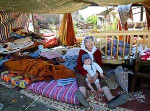 An Algerian woman sits in a makeshift shelter