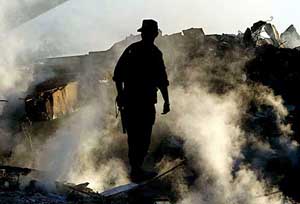 An Algerian soldier stands amongst the rubble