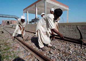 Pakistani railway workers fix a train track at the Wagah railway station near Lahore in Pakistan for possible restoration of rail link between Pakistan and India