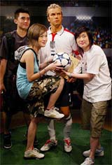 Visitors pose with wax figure of English soccer star David Beckham with his new haircut at Hong Kongs Madame Tussauds Wax Museum