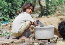 A little girl is forced to wash dishes