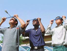 Residents watch solar eclipse through photographic negatives