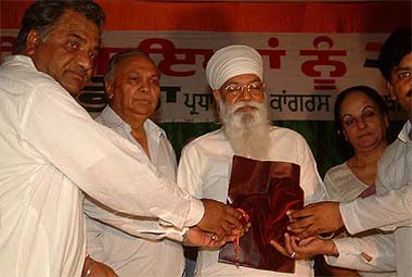 Chairman, High-Powered Finance Committee, Punjab, Surinder Singla, DCC general secretary Kewal Krishan Aggarwal present a packet