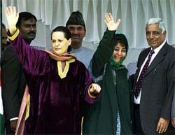 Congress President Sonia Gandhi and Kashmir's ruling party chief Mehbooba Mufti wave to the crowd while Chief Minister Mufti Mohammad Sayeed looks on