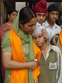 Bibi Gurdeep Kaur, a 1984 riot victim, consoles her son