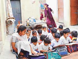 Slum children sit in a classroom of a private school run by the Godwin Education Society