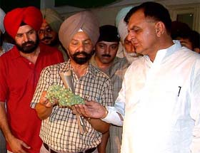 Horticulture officials show a bunch of grapes to Dr Mohinder Kumar Rinwa, Parliamentary Secretary, Horticulture and Environment, Punjab, during a state-level exhibition in Bathinda