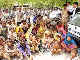 Fearing threat to their lives, 22 labourers along with their 12 children wait in front of the district courts in Chandigarh.