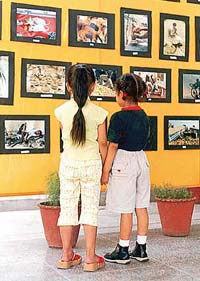 Two children look at photographs clicked by Rajesh Sachar, a photo journalist, during an exhibition in Patiala on Wednesday.