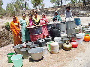 People of Jhaniari village in Hamirpur district wait for the water tanker to arrive