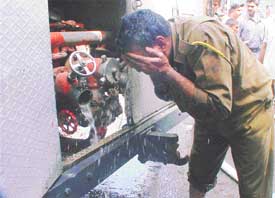 Fireman washes his face after dousing fire in a furniture shop
