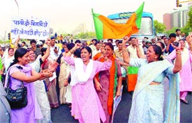 Activists of the BJP Mahila Morcha block traffic near Regal Cinema against water and electricity shortage in the Capital