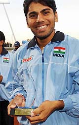 Indian goalkeeper Devesh Chauhan smiles as he walks off the pitch with the trophy following India's win over Australia
