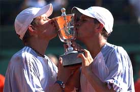 American twins Bob and Mike Bryan kiss their trophy after winning the men's double final of the French Open on Saturday