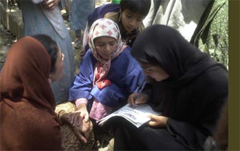 A lady helps others to put down their signatures during a signature campaign 