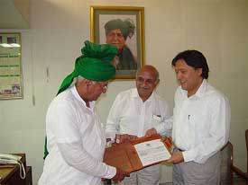 Mr Om Prakash Chautala being presented a cheque of Rs 50 lakh for the CMs Relief Fund