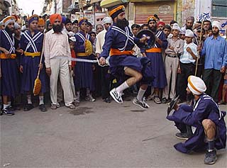 Sikh youths perform gatka at nagar kirtan in Ambala on Sunday on the eve of the martyrdom day of Guru Arjan Dev