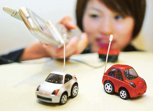 An employee of Japanese toy maker Takara Co demonstrates the companys cellphone radio control toy cars at a toy fair in Tokyo. 