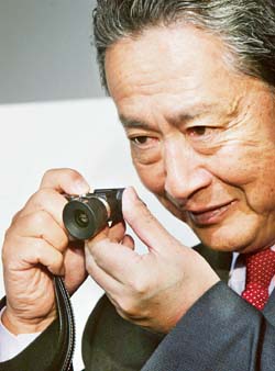 Sony Corporation Chairman Nobuyuki Idei holds the electronics giants new compact two mega-pixel digital still camera QO16-WE1, equipped with a newly-developed touchpad for digital zoom and shooting modes, at an unveiling in Tokyo. 