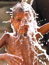 A slum dweller pours water over himself