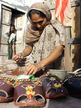 A woman fixes 'ghungru' on Punjabi jutti