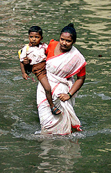 A mother carries her child in her arms