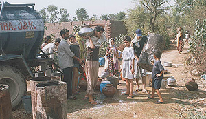 Men, women and children of Parjani village in the kandi area of Samba get water from a tanker as drinking water sources have dried up because of hot summer. 