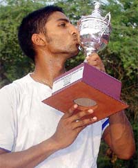 Prakash Amritraj kisses the trophy after winning the men's singles title at the ITF Men's Satellite Circuit