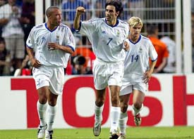Robert Pires of France celebrates with teammates Mikael Silvestre and Jerome Rothen after converting a penalty kick 