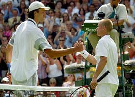 Ivo Karlovic of Croatia shakes hands with Lleyton Hewitt of Australia 