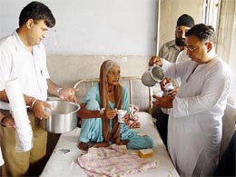 Martyr Capt Atul Somra's family members distribute milk and bread at the civil hospital in Ambala