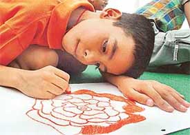 A child participates in a painting competition on the theme of the magic of banking organised by Standard Chartered Bank, Sector 9