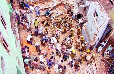 Firemen and some residents doing the rescue job after the collapse of an old multi-storeyed building at Turkman Gate area in the Capital on Saturday.