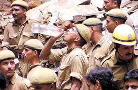 BEATING THE HEAT:  A fireman quenching his thirst during a rescue operation in Turkman Gate area where a four-storeyed building collapsed in the Capital on Saturday. 