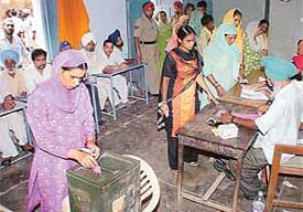 A women casts vote at a polling booth during the panchayat elections at Mullanpur Garibdass