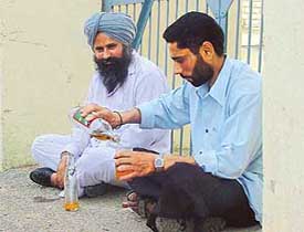 A duo enjoys a drink near a polling booth at Barundi village
