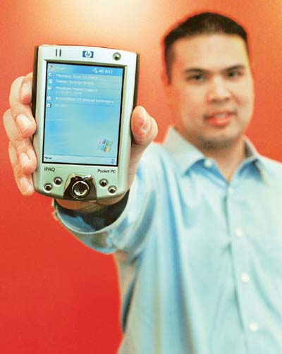 Ed Suwanjindar of Microsoft shows the new Windows Mobile 2003 software for Pocket PCs on a HP iPAQ 2210 handheld in Redmond, Washington. 