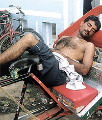 LIFE NO BED OF ROSES: A rickshaw-puller trying to snatch forty winks after a hard day in the Capital.