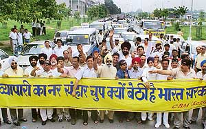 Members of the Chandigarh Beopar Mandal hold a car rally in protest against the Rent Act notification