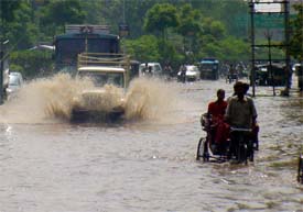 A jeep wades through a flooded street