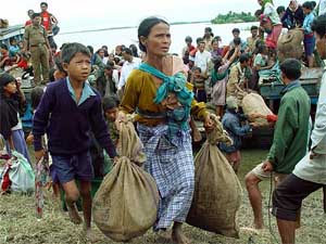 Flood victims carry their belongings after being rescued in Demaji district, 550 km east of Guwahati,