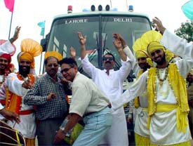 Pakistani travellers perform bhangra during their halt for lunch at Sirhind