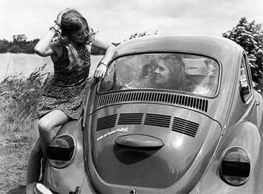 A 1970's promotional photograph from Volkswagen's historical archives shows two women and a VW Beetle